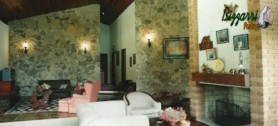 Revestimento de pedra na parede, com pedra moledo, em sala de estar em residência em sítio em Bragança Paulista-SP.