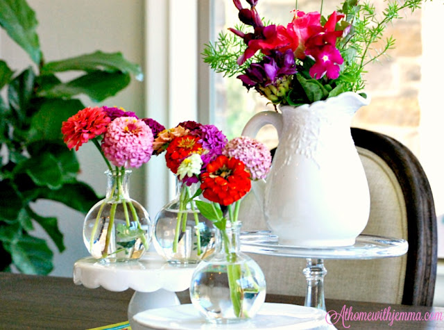 French dining table with flowers and the Coaxing Fall Winner fiddleleaf fig-cake stands- clear vases, zinnias, french table, french chairs