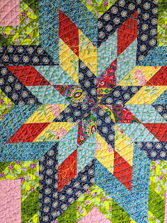 The center star of the Lone Star is machine quilted with FMQ orange peels and then switches to echo quilting in a spiral for the rest of the quilt.