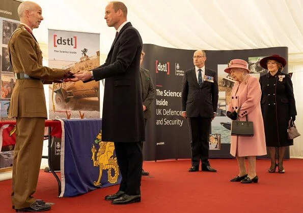 Queen Elizabeth wore a pink coat by Stewart Parvin and matching hat by Rachel Trevor-Morgan. Carved Ruby, gold and diamond brooch, Grima ruby brooch