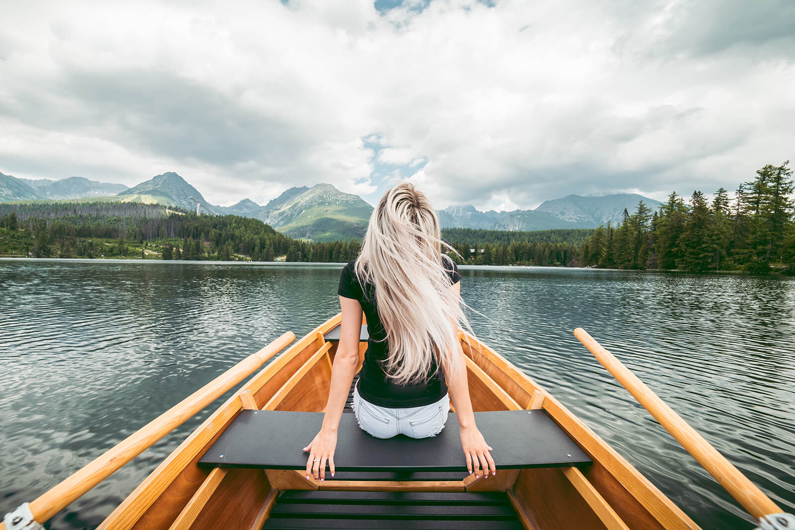 فتاة تجلس في قارب وسط المياه الصافية