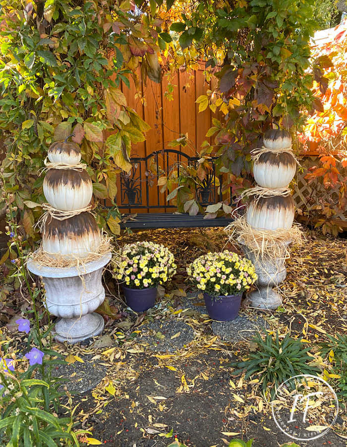 Unique Rust Paint Dripped Abstract Pumpkin Topiaries with white artificial stacked pumpkins and rust activated paint to decorate outdoors for fall.