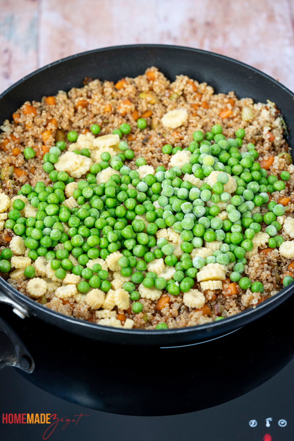 Adding in peas and corn to quinoa rice