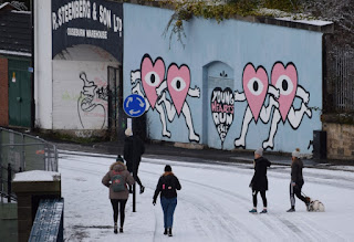 People out walking past grafitti at Steenbergs Yard