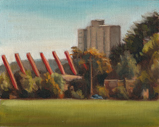 Oil painting of distant high-rise flats with red angled pillars in the middle ground and trees and buildings in the foreground.