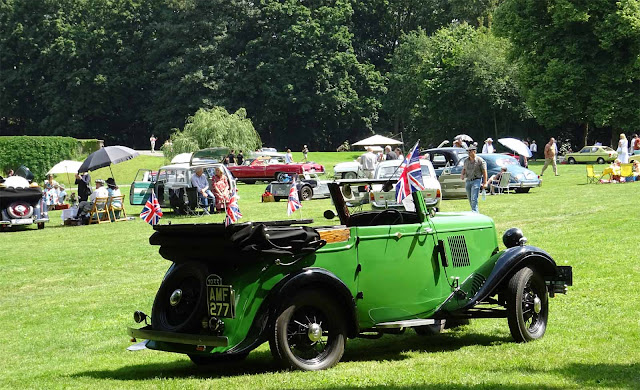 Oldtimer Cabrio ohne Picknick auf Schloss Merode mit anderen Fahrzeugen im Hintergrund Grünes Oldtimer Cabrio mit englischen kleinen Flaggen auf dem Rasen des Schlossparkes auf dem 1. Fashionaward