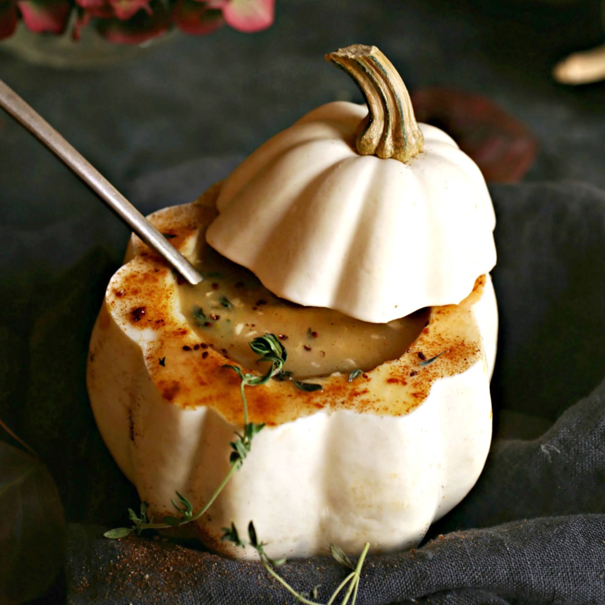 Recipe for a creamy acorn squash and potato soup, flavored with cumin and fresh thyme.