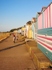 Cycling on the prom by colourful beach huts