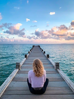 woman sitting on pier