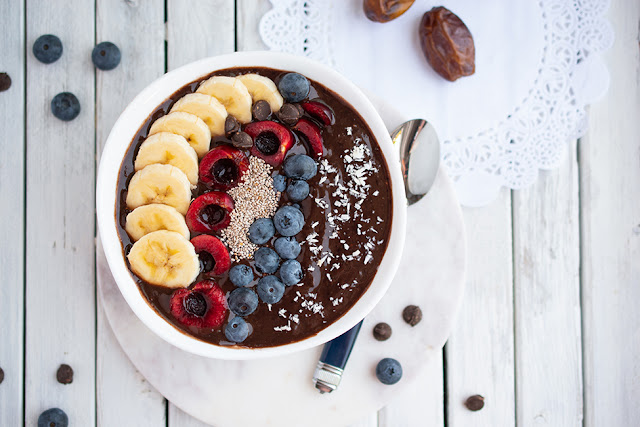 Vegan and gluten-free chocolate date smoothie bowl with fruit toppings in bowl