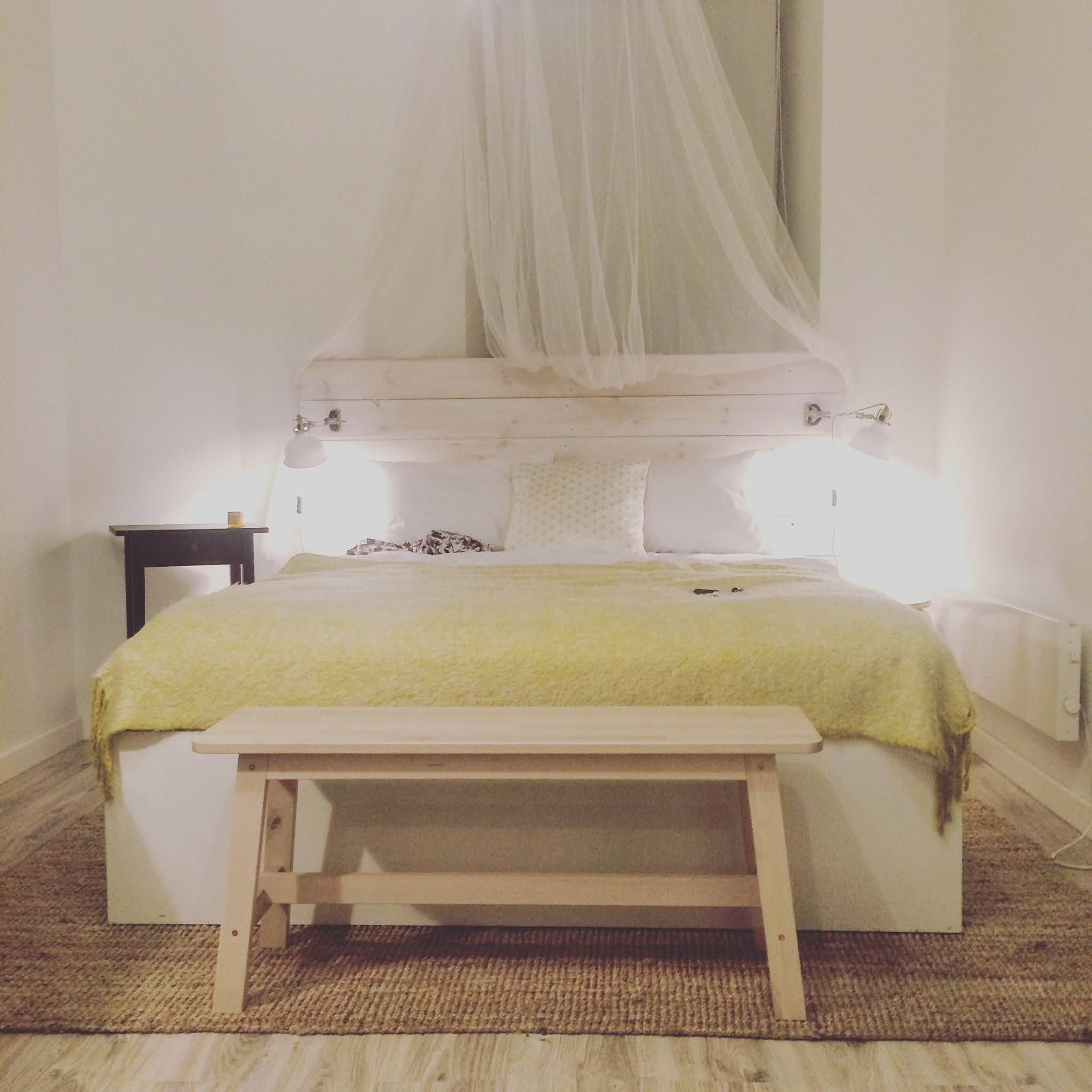 bed with yellow bedspread and wooden floors