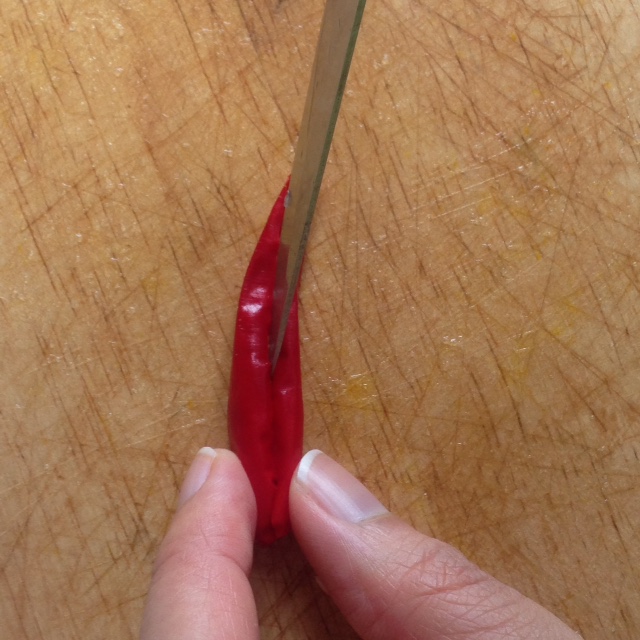 red thai chili being sliced