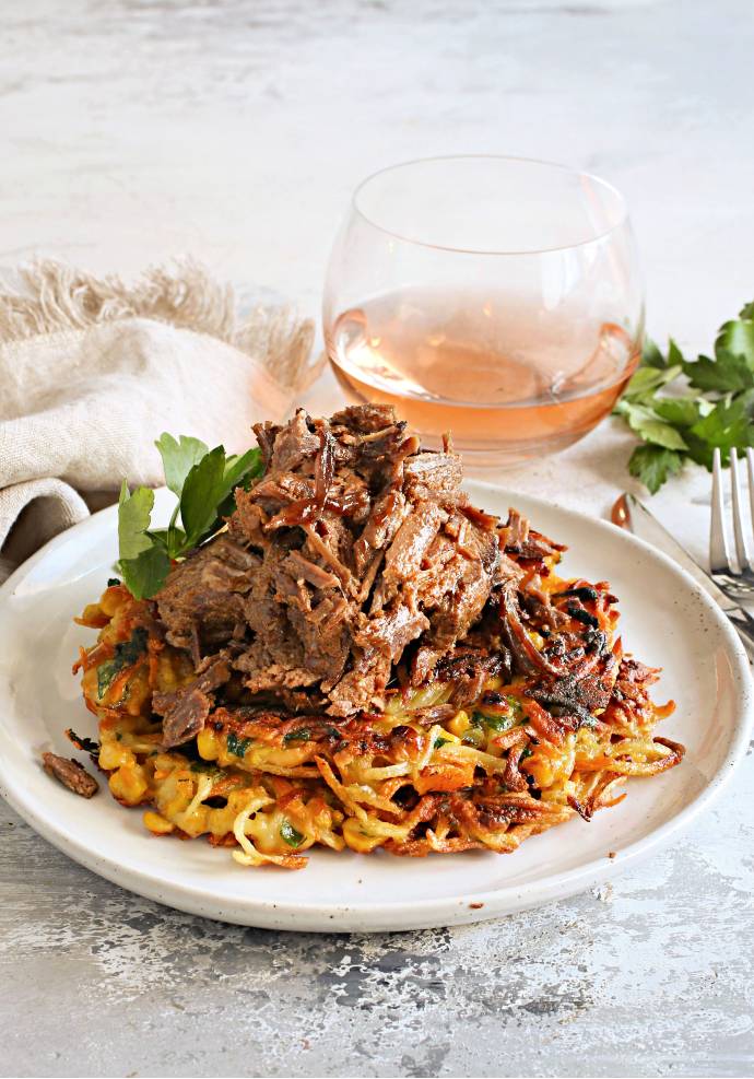 Recipe for a beef brisket, rubbed with mustard, liquid smoke and spices, wrapped and slow cooked in an oven and served over vegetable fritters.