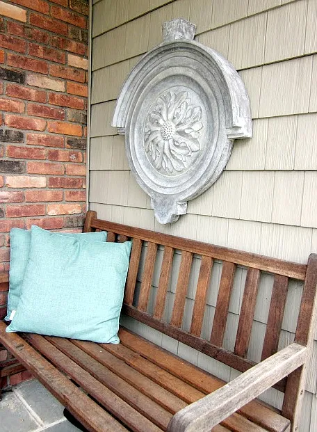 Teak bench with wall hanging and pillows