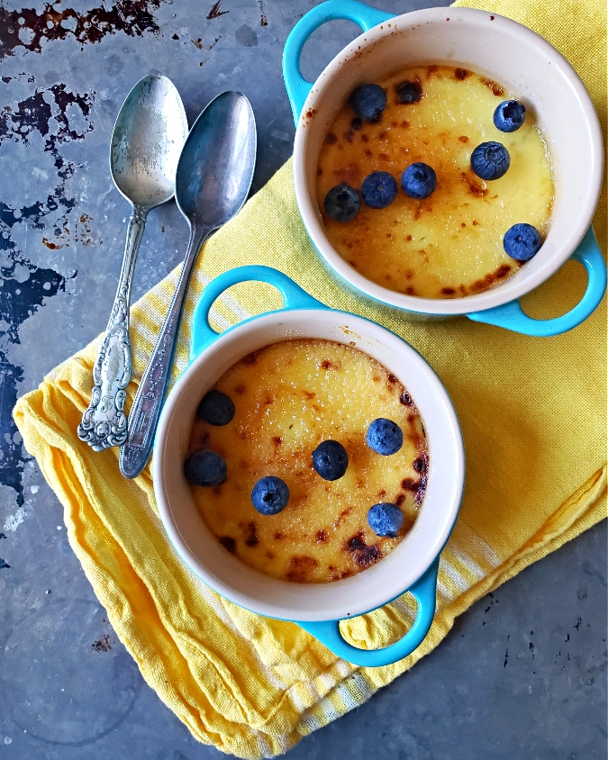 2 mini creme brulee desserts in Le Creuset with blueberries