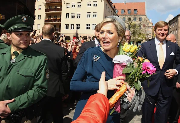 King Willem-Alexander and Queen Maxima of the Netherlands cross the Townhall square
