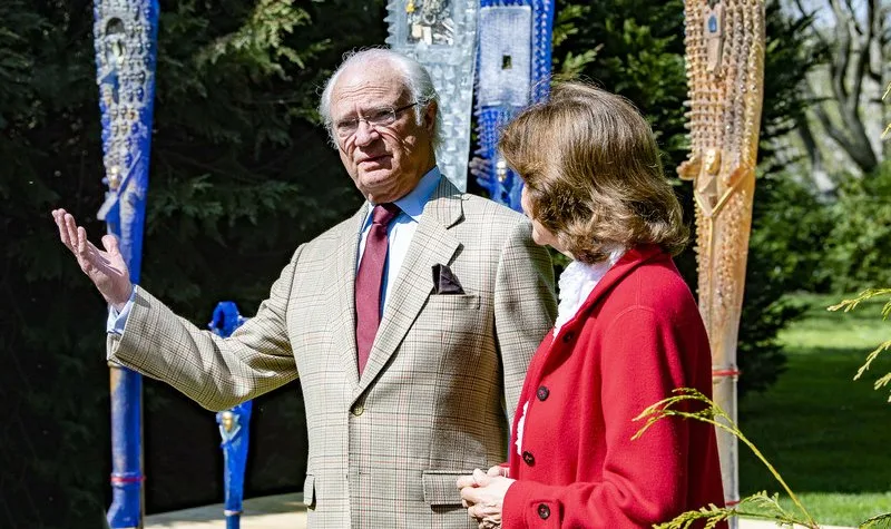 Queen Silvia wore a red jacket and white ruffled blouse from Newhouse, black trousers