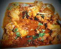 Serving cooked chicken curry with coriander leaves garnish for chicken curry recipe