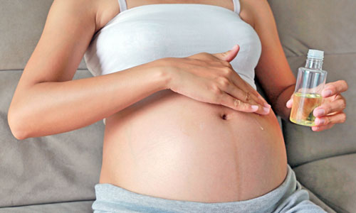 Poner aceite en la barriga de la embarazada para prevenir estrías
