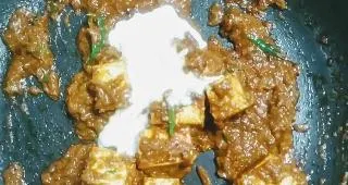 Pouring fresh cream into the paneer butter masala recipe
