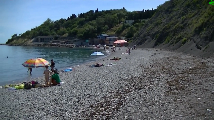 Пляж Алупки с большими камнями шезлонгами