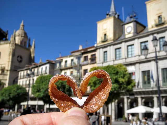 Heart shaped piece of a florone against the backdrop of Plaza Mayor in Segovia, Spain