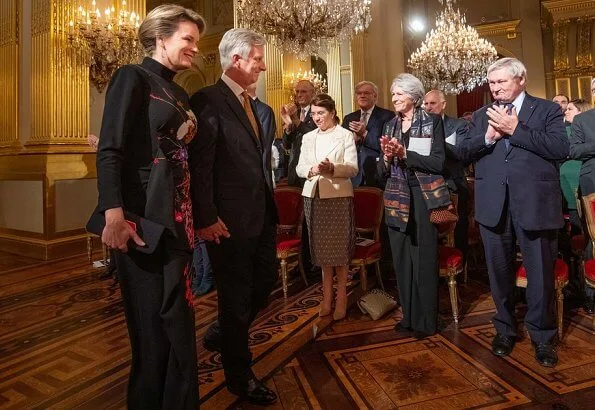 Queen Mathilde wore a floral print gown by Dries Van Noten. Crown Princess Elisabeth wore a velvet-satin jumpsuit by DVF