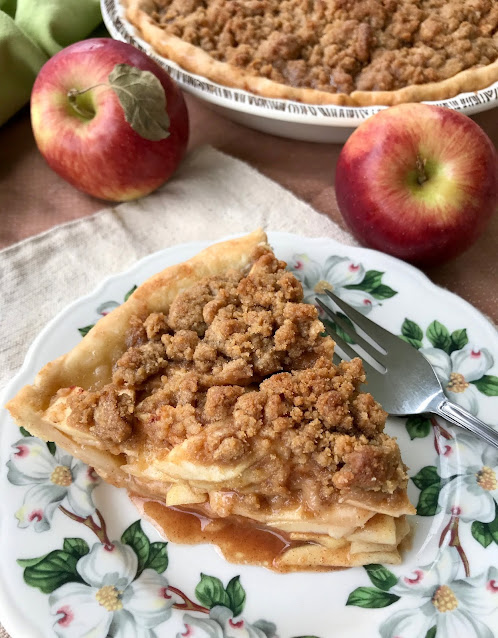 Slice of apple crumb pie on a serving plate.
