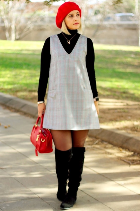 Sweet woman wearing a gray mini dress, black tights and over the knee boots