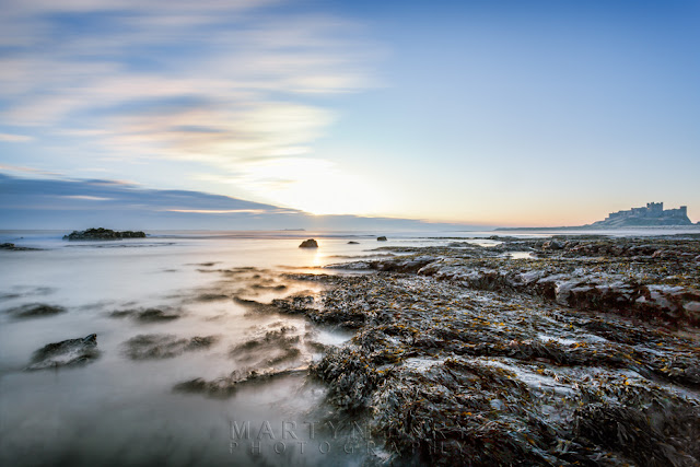 Bamburgh Castle in Northumberland at sunrise with a long exposure by Martyn Ferry Photography 