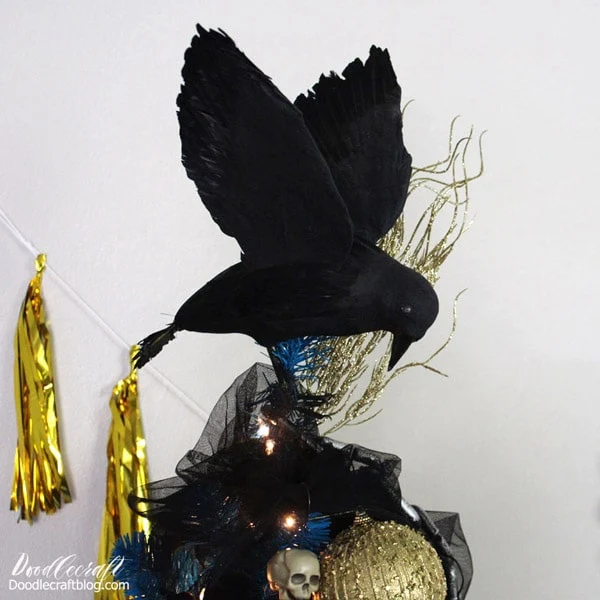 Make a haunted display in your home with a bright blue Christmas tree decorated with spooky skulls, pumpkins, chains and topped with black crows for the perfect Halloween tree.