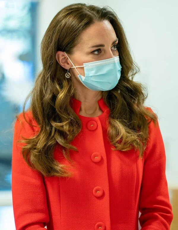 Kate Middleton wore a red coat from Eponine, and a camel pleated skirt. Mappin and Webb Earrings. Demellier London Nano Montreal leather satchel