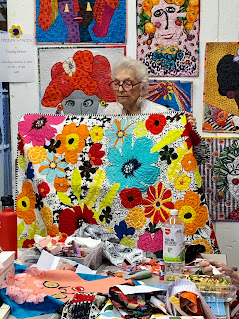 Freddy holds one of her floral collage quilts at New Pieces Quilt Shop, Berkeley CA