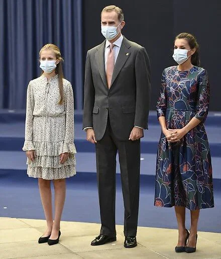 Queen Letizia wore a dress by Carolina Herrera. Crown Princess Leonor wore a print dress by Poeta. Infanta Sofia wore a red shirt dress by Mango