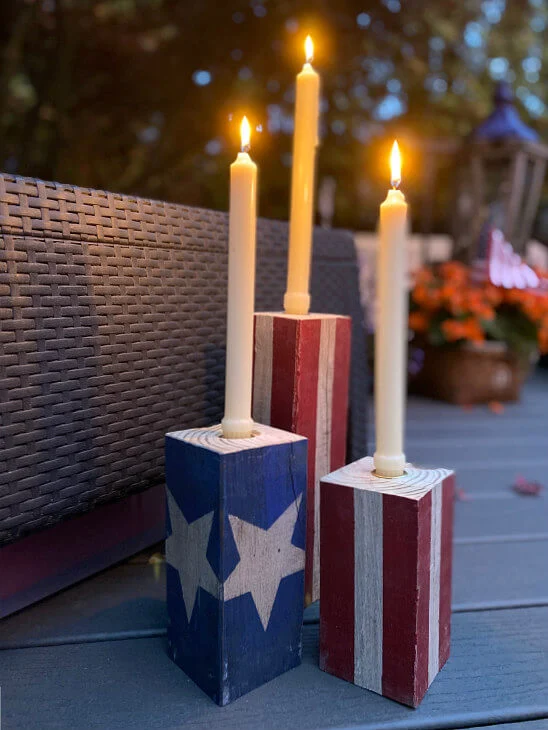 Candle holders painted in red, white, and blue with lit candles