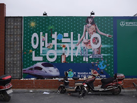 Wanda Plaza "안녕하세요" sign on a wall bordering a construction site in Mudanjiang, China