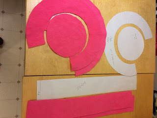 Pattern pieces for hat and pieces cut from pink fleece.