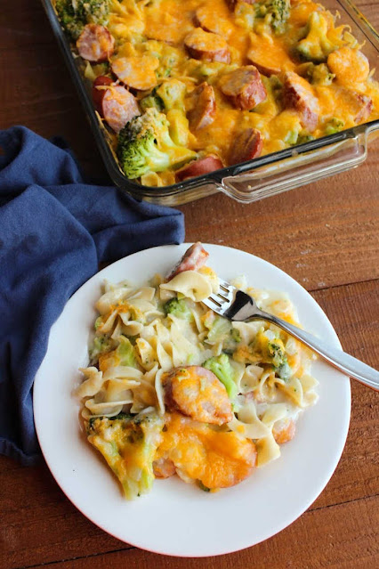 This yummy casserole has all of the good stuff, pasta, broccoli, kielbasa sausage and plenty of cheese. It comes together quickly and can be prepped ahead of time for a tasty family dinner. forkful of cheesy pasta, broccoli and sausage ready to eat