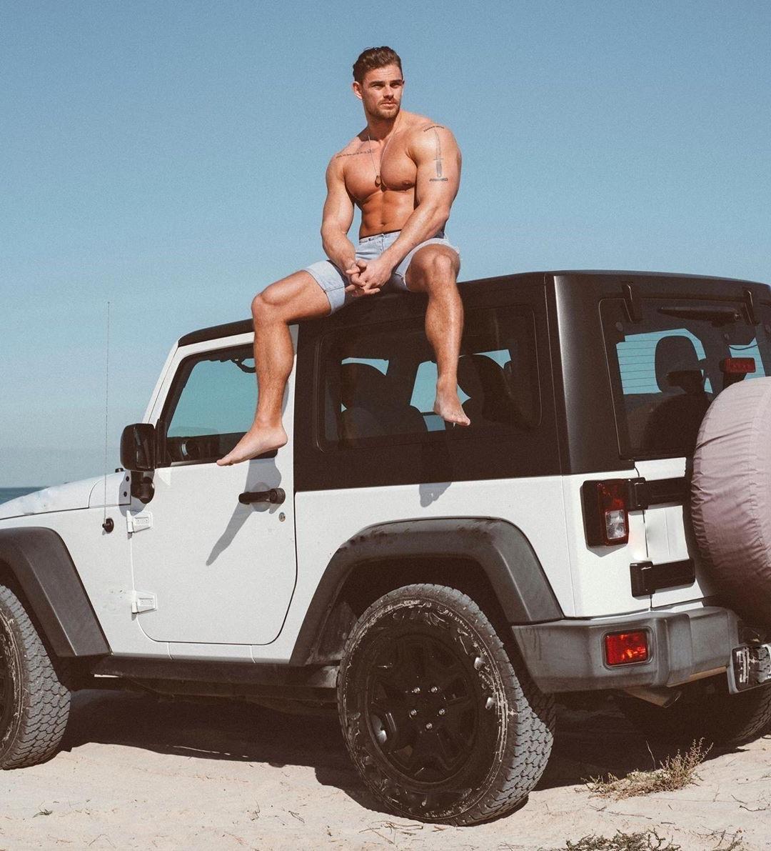 shirtless-fit-musle-beefy-hunk-sitting-car-beach-day