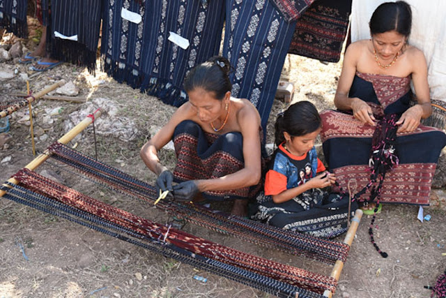 Молодые девушки изучают процесс окрашивания и ткачества среди падеро