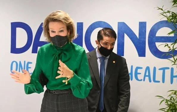 Queen Mathilde wore a new green bow blouse from Carolina Herrera and grey check print trousers from Natan. She visited the facilitys of Danone