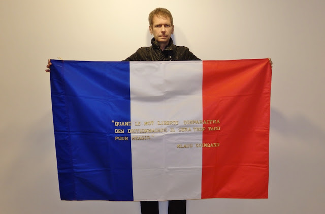 Klaus Guingand and his flag with the sentence in French.