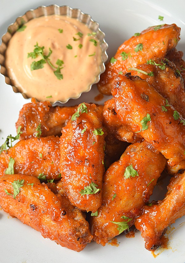 Top view of a white plate with honey hot chicken wings