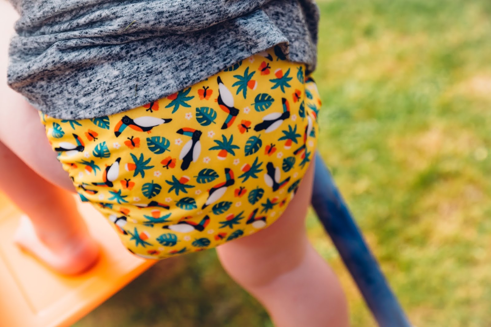 close up of a miosolo cloth nappy being worn by a toddler playing outdoors