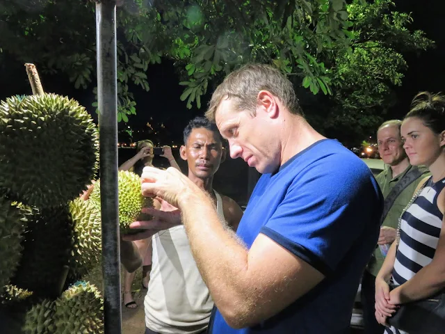 Steven from Siem Reap Food Tours selecting a durian