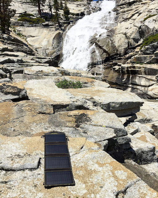 Sunjack 14W Portable Solar Charger on the rocks charging