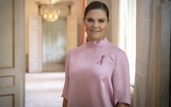 Princess Victoria wore a pink silk top from Rodebjer. The designer of this year's Pink Ribbon is First Aid Kit, Klara and Johanna Söderberg