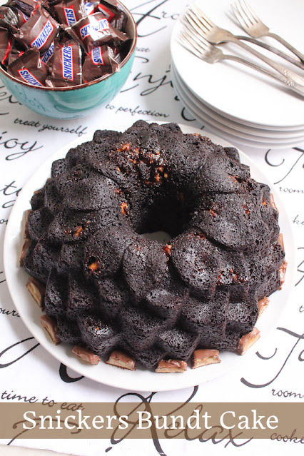 Food Lust People Love: This Snickers Bundt Cake is rich and super chocolate-y with a tender crumb. The Snickers pieces sink to the bottom of the pan while baking which means the top of the cake is full of them! Pour yourself a cold glass of milk and enjoy a large slice!