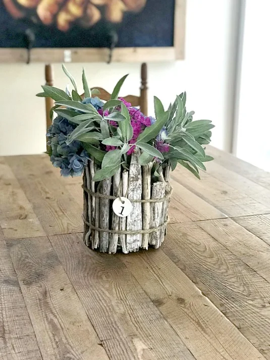 Driftwood vase and sage flowers on a wooden table