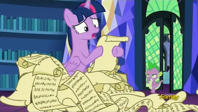 Twilight buried in scrolls as Spike looks on